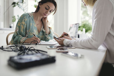 Female colleagues working on table in home office