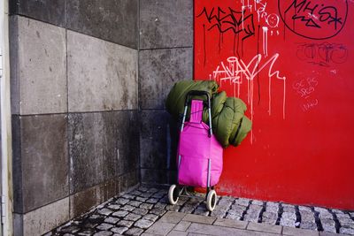 Wheeled luggage with sleeping bag against wall