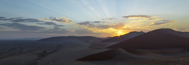 Scenic view of desert against sky during sunset