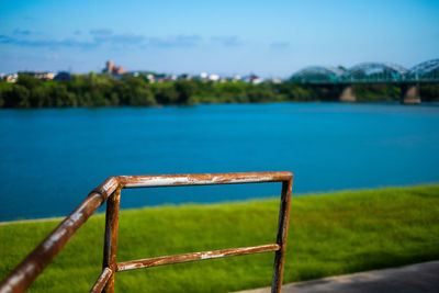 Swimming pool by lake against sky