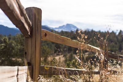 Close-up of wooden post on field against sky