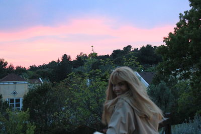 Woman in park against sky during sunset