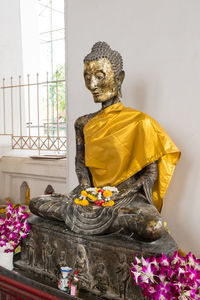 Buddha statue against wall in ancient temple