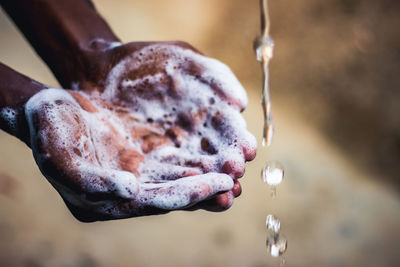 Close-up of hand holding wet leaf