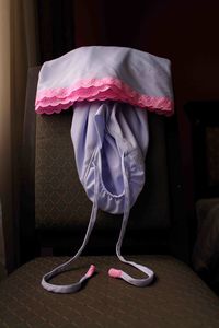 Rear view of girl holding umbrella at home