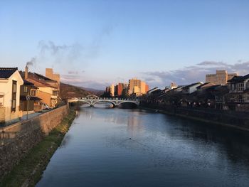 River amidst cityscape against sky