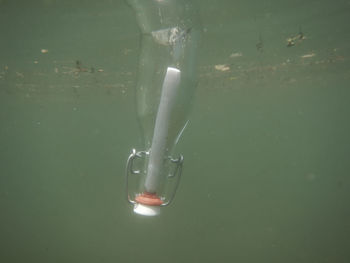 View of glass bottle with message sinking in water