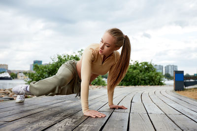 Portrait of young woman standing on boardwalk