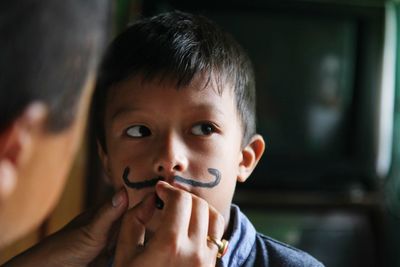 Close-up portrait of boy holding camera