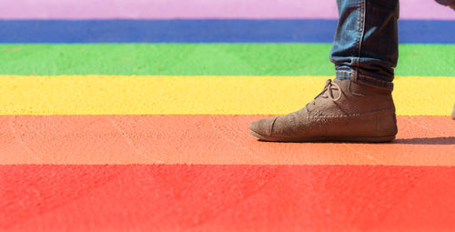 Low section of woman standing on multi colored road