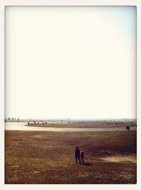 People on field against clear sky