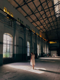 Rear view of woman walking in building