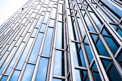 Low angle view of glass building against sky