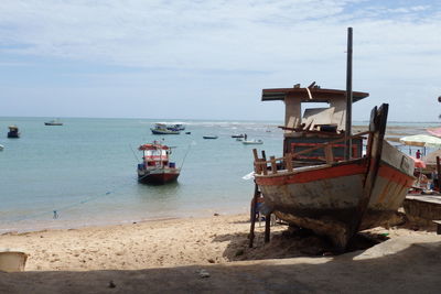 Scenic view of boats on beach with sea in background