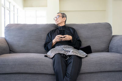 Young man sitting on sofa