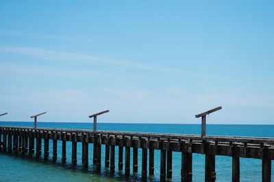 Pier over sea against blue sky