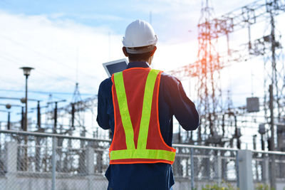 Rear view of man standing at construction site