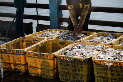 Low section of man standing by fish in market