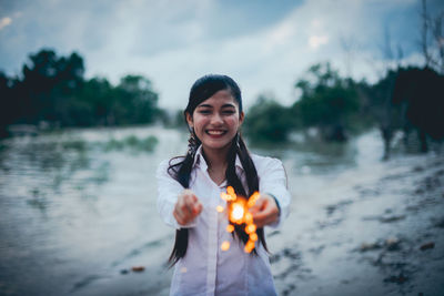 Portrait of a smiling young woman standing in water