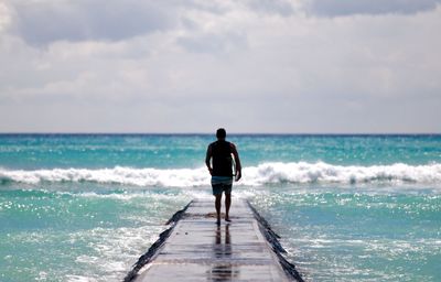 Rear view of man standing on beach