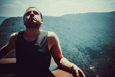 Man standing at observation point against mountain range