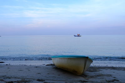 Boat moored on sea against sky