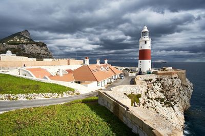 Lighthouse by sea against sky