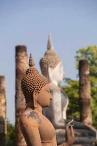 Statue against temple building against clear sky