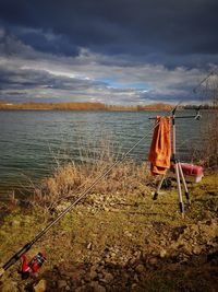 Deck chairs on shore against sky