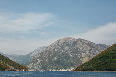 Scenic view of sea and mountains against sky