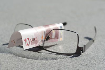 Close-up of eyeglasses with paper currency on table