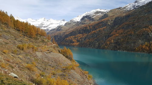 Scenic view of lake by mountains against sky