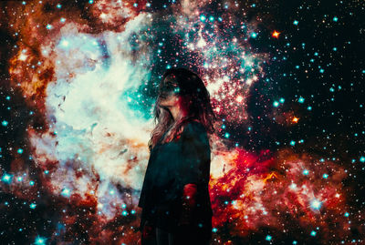 Digital composite image of woman standing against illuminated sky at night