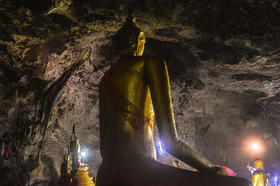 Low angle view of statue against illuminated building