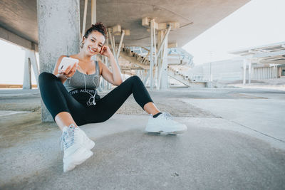 Full length of young woman exercising on street