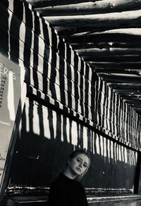 Portrait of young woman standing on ceiling