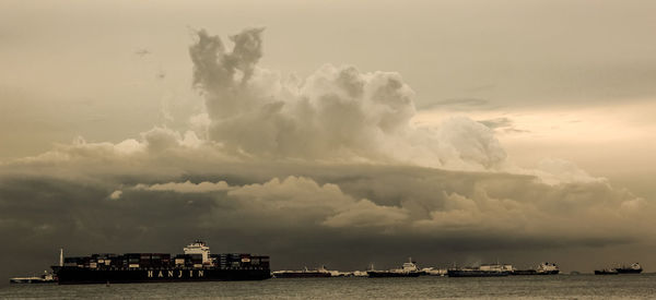 Ship in sea against cloudy sky