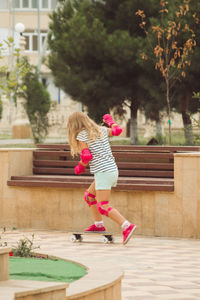 Girl with a skateboard in pink knee pads