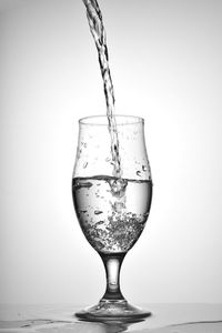 Close-up of wineglass on table against white background