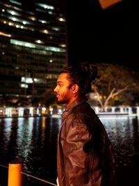 Side view of young man looking away at night