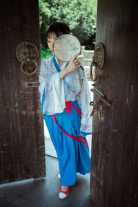 Rear view of woman standing with umbrella
