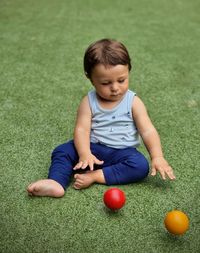 Portrait of boy playing with ball on grass