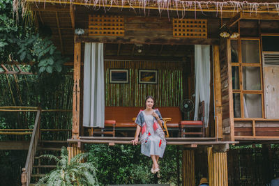 Full length of woman standing outside house