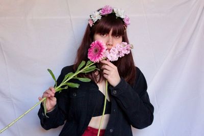 Portrait of woman standing against white wall