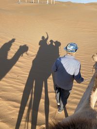 High angle view of people walking on sand at beach