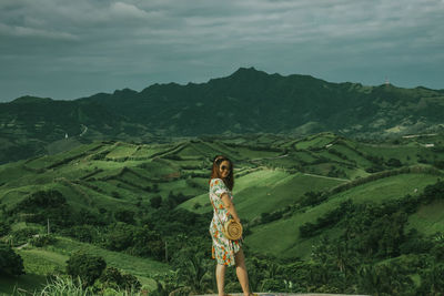 Portrait of woman standing on mountain against sky