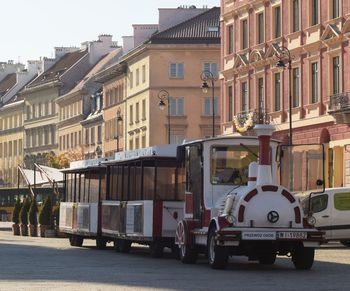 Vehicles on road by buildings in city