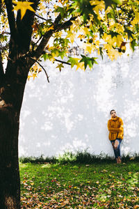 Man standing by flowering tree on field