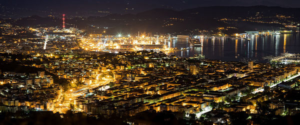 Illuminated cityscape against sky at night