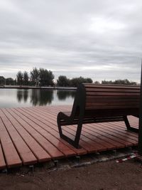 Bench in park against sky